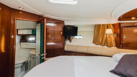 The bedroom of motor yacht Unplugged includes a private bathroom and a cozy atmosphere.