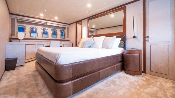 The master cabin of motor yacht Five Stars features a large bed and luxurious decor.