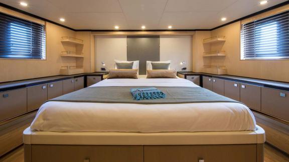 Doppelbett, Fenster mit Jalousien und viel Stauraum in der Kabine der Sea Story Yacht.