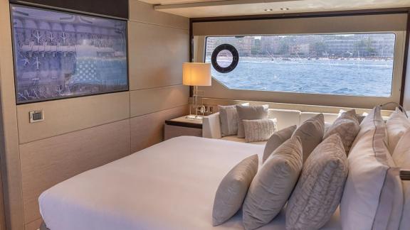 The master cabin of Lady M in Mallorca includes a large window, seating area and TV.
