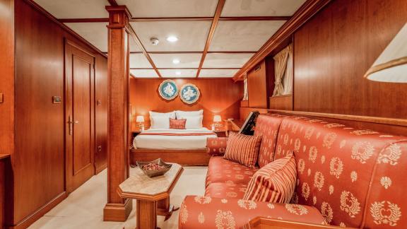 Die Suite der Motoryacht Seagull 2 mit rotem Wohnbereich und bequemem Bett bietet luxuriöses Wohnen.