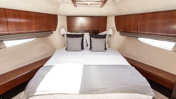 Bright guest cabin with side windows and a wide bed on Le Chiffre motor yacht.