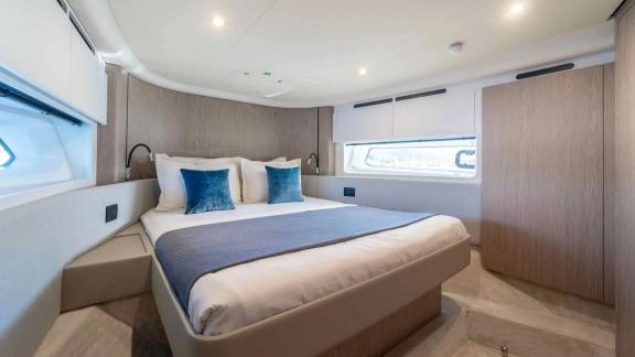 Stylish guest room with double bed and large windows offering natural light and sea views.