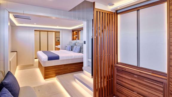 Spacious cabin features double bed, wooden details and soft ambient lighting.