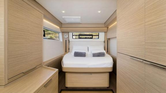 В каюте — большая кровать, окна по бокам и спереди, потолочный люк и встроенные шкафы.