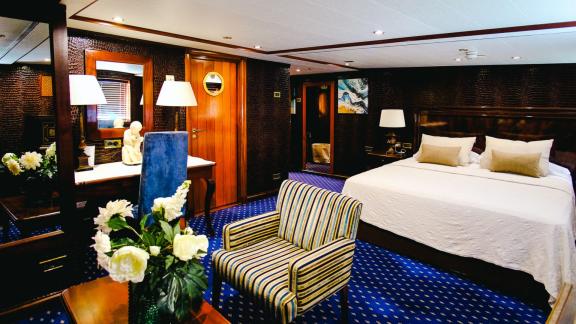 Die Hauptsuite der Motoryacht Harmony II bietet ein großes Bett, eine Sitzecke und elegante Dekorationen.