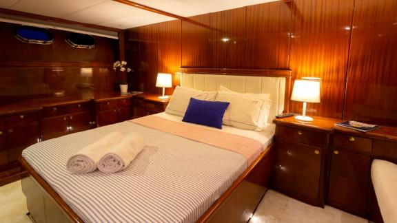 The master cabin of Sveti Sky features a double bed, bedside lamps and polished wooden panels.