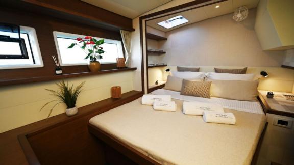 The double cabin of Ace of Hearts in Athens features a large bed, side windows and wooden details.