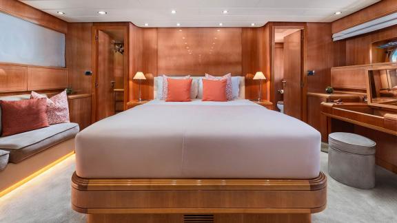 The master cabin of Dream motor yacht in Athens features a double bed, vanity desk and private bathroom access.