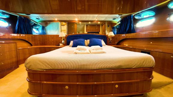 The master cabin of motor yacht Riva 21 features a large bed, comfortable pillows, and elegant decor.