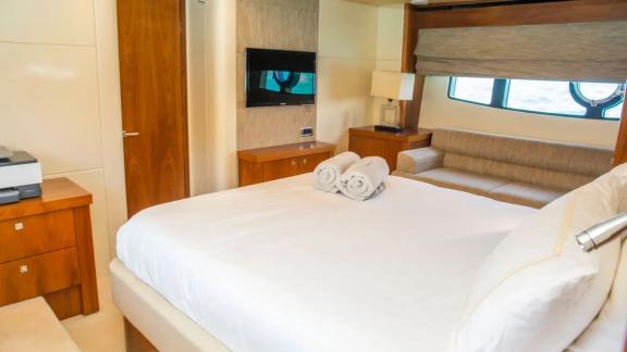 Spacious bedroom with TV and sofa on the Midnight Summer Dream yacht.