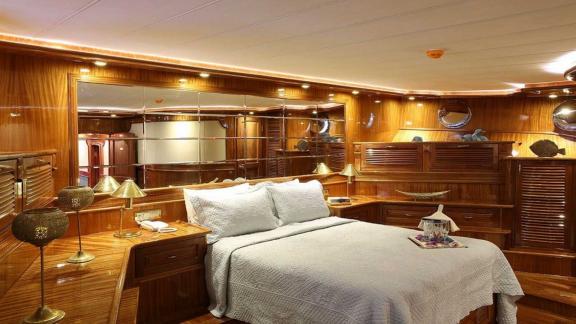 The cabin of Queen Atlantis stands out with elegant wooden design and a comfortable bed.