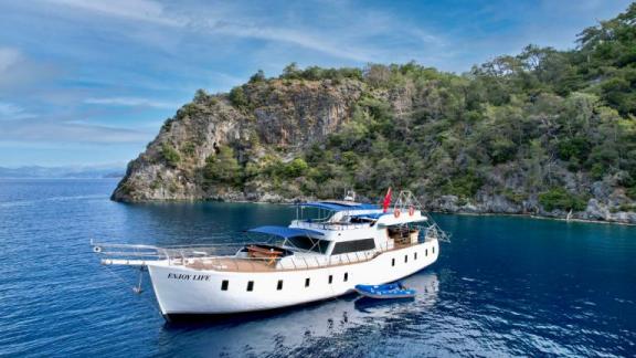 The 6-cabin gulet Enjoy Life is idyllically situated off a wooded coast in Fethiye.