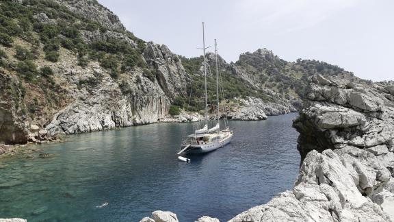 The Silver Moon is anchored in a peaceful cove with crystal-clear water.