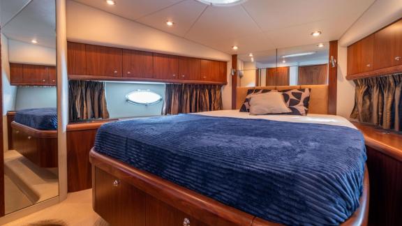 Komfortable Gästekabine mit Holzverkleidung auf der Motoryacht Shadow vor Ibiza.