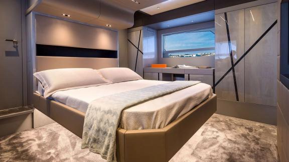 Comfortable cabin with large window and double bed on a yacht near Mallorca.