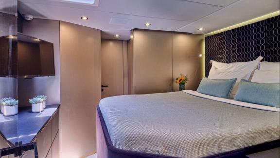 The modern cabin of Adara yacht offers a peaceful setting with sleek design and a cozy bed.