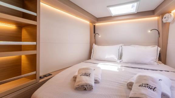 The double cabin of Aranel catamaran in Lefkada features a large bed, skylight and built in shelves.