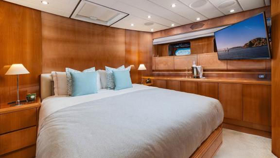 The VIP cabin of Dream motor yacht in Athens features a double bed, TV unit and wooden cabinets.
