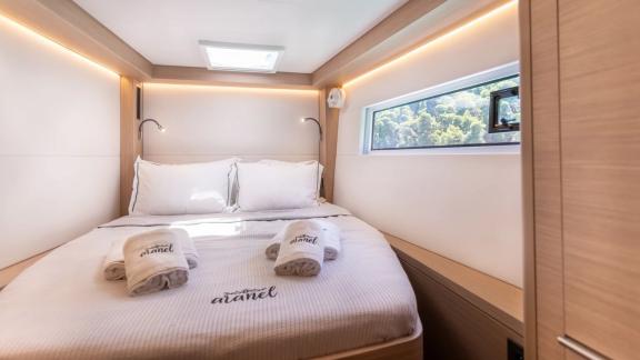 The guest cabin of Aranel catamaran in Lefkada features a double bed, side window and skylight.