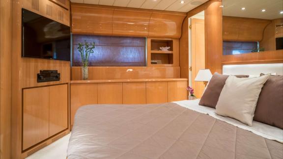 Zu sehen ist die Masterkabine der Motoryacht Atrato in Athen mit Doppelbett und TV-Bereich.