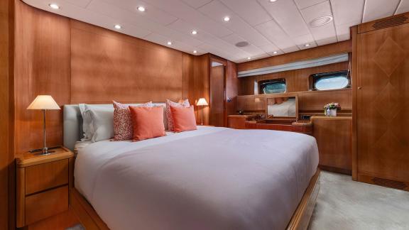 The double cabin of Dream motor yacht in Athens features a large bed, desk area and storage cabinets.