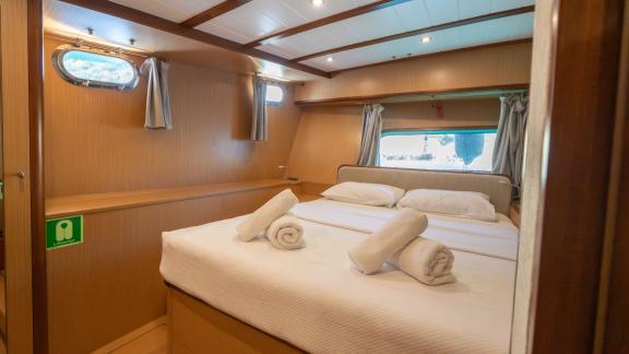 В Бодруме аренда гулета Giulia каюта с кроватью и окном у борта.