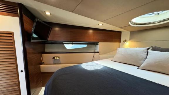 The double cabin on motor yacht Breathe is equipped with a spacious bed and a television.