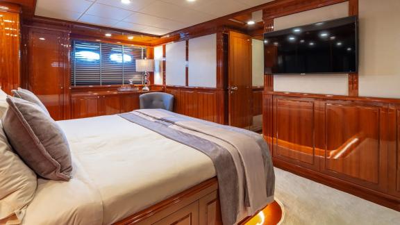 The master bedroom on Divine yacht features a large TV and cozy seating area.