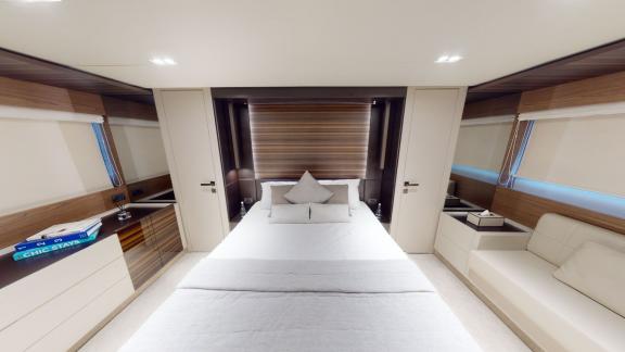 The spacious bedroom of the Ferretti 670 motor yacht offers comfort and elegance for your Dubai yacht rental experience.