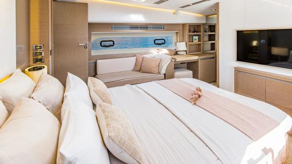 The master cabin of Blue M yacht in Mallorca features a sofa, desk and sea-facing window.