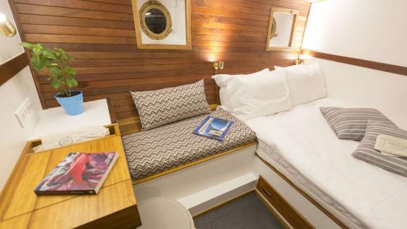 Cosmos offers a stylish cabin with a single bed, reading nook, and wood accents.