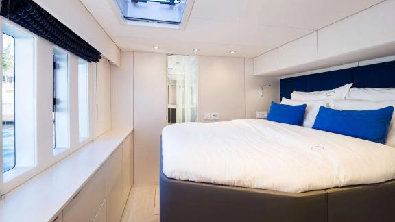 The bright cabin of Sunreef 50 Solitaire features a spacious bed, large windows, and stylish interior for restful stays.