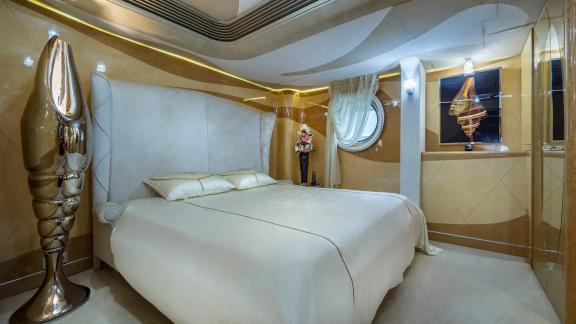 Thunder yatının misafir odası, altın tonlarında şık tasarımıyla lüks bir ortam sunuyor.