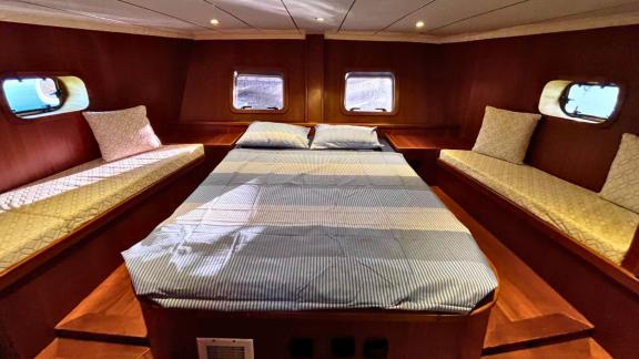 The cabin of Gulet Ahmet Ertürk features a large bed and side seating areas.