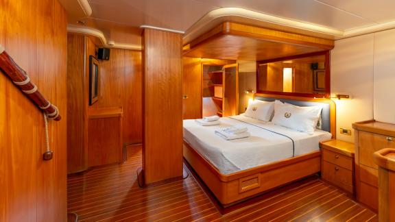 The cabin of Mein Schatz features warm wood decor and a cozy bed, perfect for a gulet charter in Bodrum.