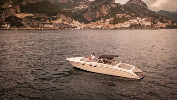 Die Motoryacht Gj ankert vor der beeindruckenden Kulisse von Amalfi. Perfekt für eine tägliche Yachtcharter.