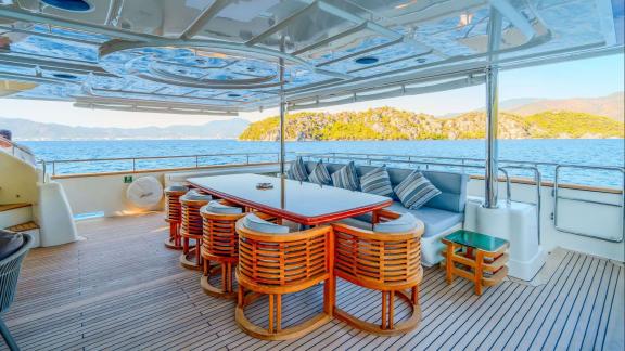 Ariela’s aft deck features cushioned corner seating and a high table overlooking the Göcek coastline.