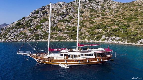 Luxurious gulet Vesta 1 Sevil in the blue waters off the rocky coast of Marmaris.