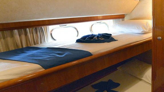 Das Gästezimmer der Motoryacht Mary mit Etagenbett und Bullaugenfenstern.