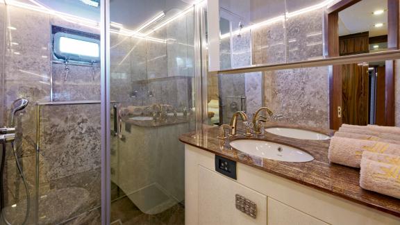 Stylish bathroom on the motor yacht Wide Liberty with a large shower and double sinks.