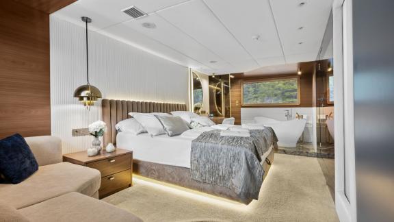 Modern guest cabin with king-size bed and luxurious bathtub.