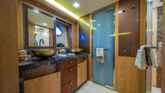 The Monte Carlo 86 Giorgio bathroom features twin sinks, natural light and elegant wood finishes.