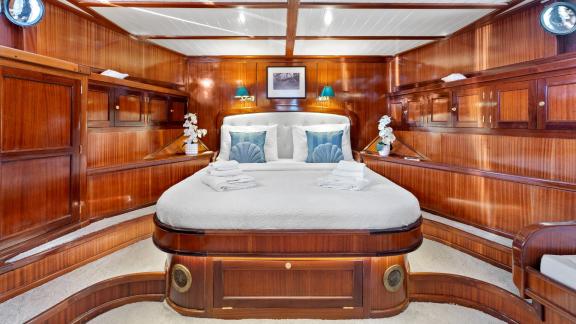 An elegantly laid dining table on the deck of the gulet Smart Spirit, with a view of the sea and the surrounding coastli