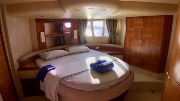 Geräumiges Schlafzimmer auf der Motoryacht Cosmos mit großem Bett und herrlichem Meerblick.