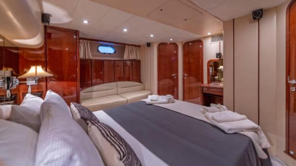 Spacious and comfortable bedroom on the River S motor yacht with an elegant seating area.