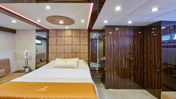 Elegant master cabin of the motor yacht Wide Liberty with a large bed and modern accents.