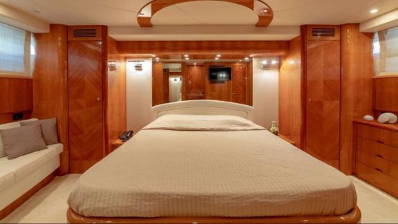 The master cabin of the Venus Secrets yacht offers a luxurious experience with a large bed, mirrored walls, and seating 