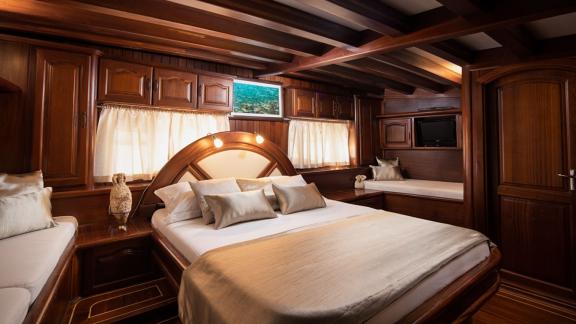 A stylish cabin on the gulet Nostra Vita in Croatia, equipped with elegant wooden furniture and cosy lighting.