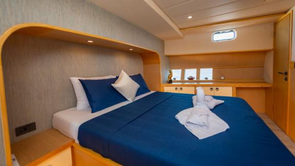 The master cabin of trawler yacht Kaan Bey 2 features modern design and a comfortable bed.